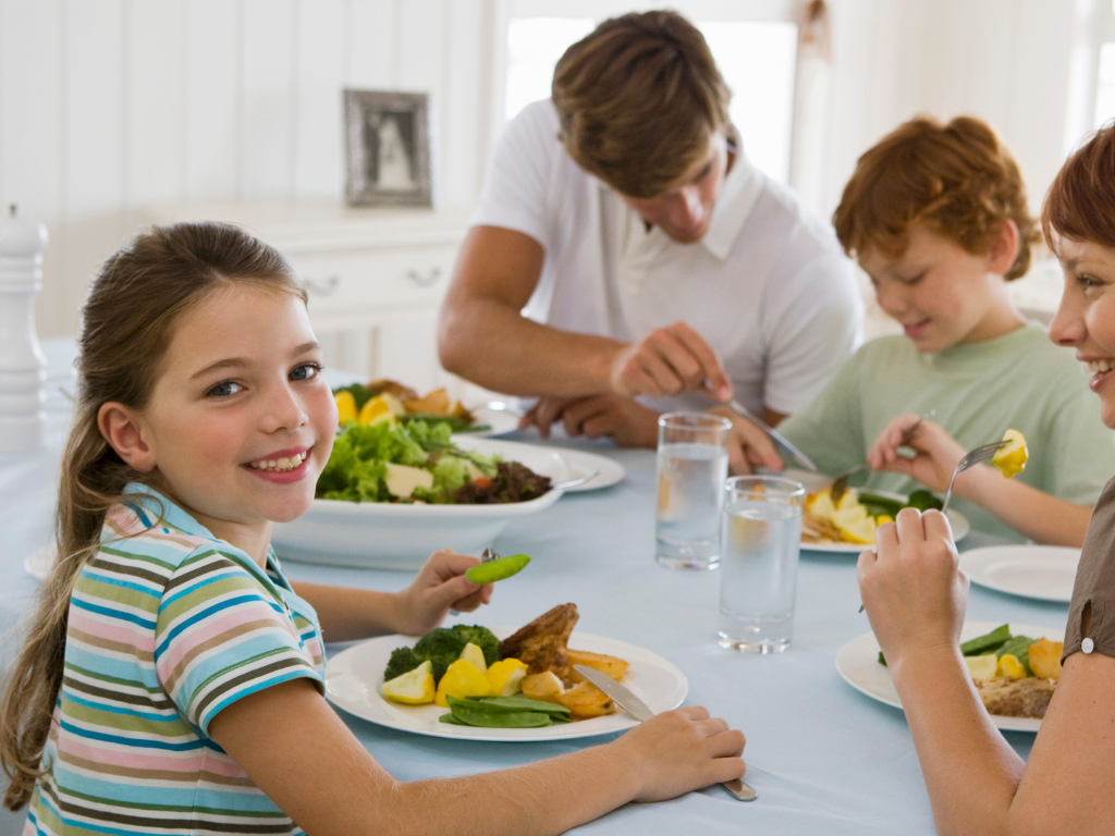 A joyful family enjoys a healthy homemade dinner together—capturing the spirit of connection and the impact of kids cooking classes near Chicago, Crest Hill, and Mokena
