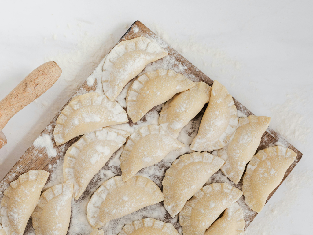 Freshly made dumplings dusted with flour, ready to cook—perfect for showcasing authentic hands-on cooking classes in Mokena, Crest Hill, and the greater Chicago area
