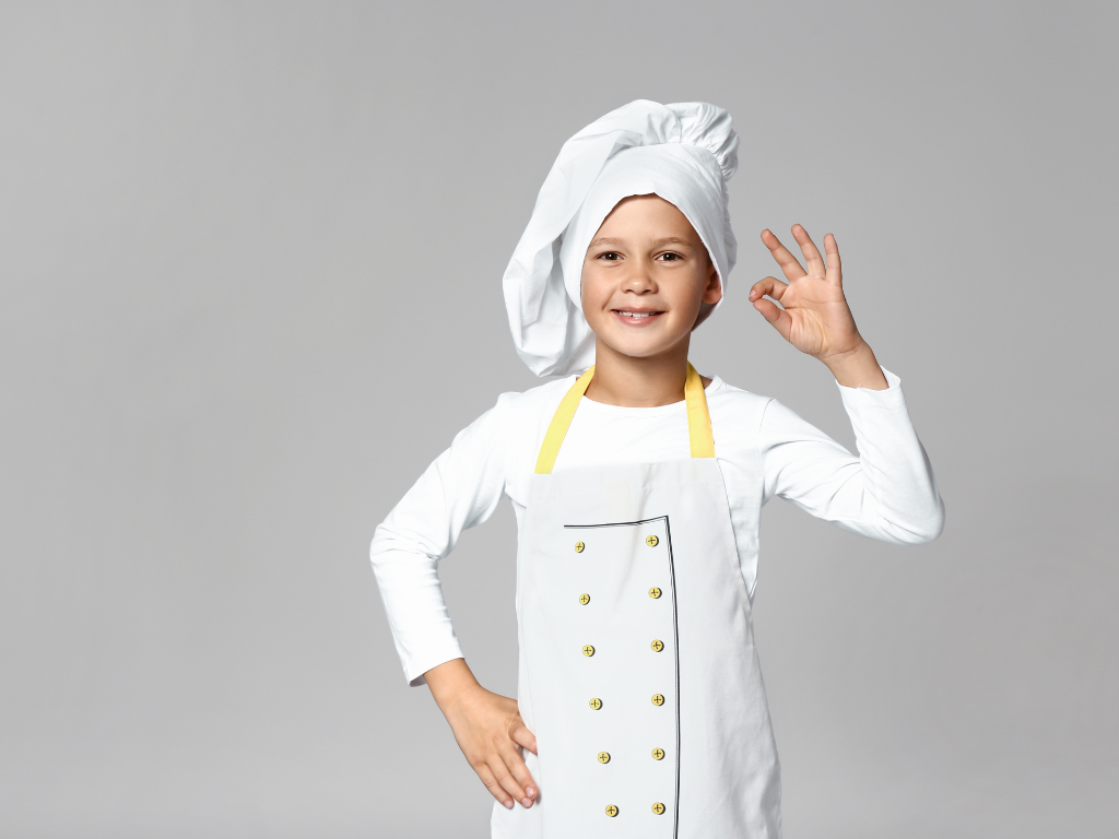 A young chef proudly gives an “okay” sign in this bright, professional cooking class image—ideal for promoting youth culinary programs in Mokena, Crest Hill, and Chicago, Illinois.
