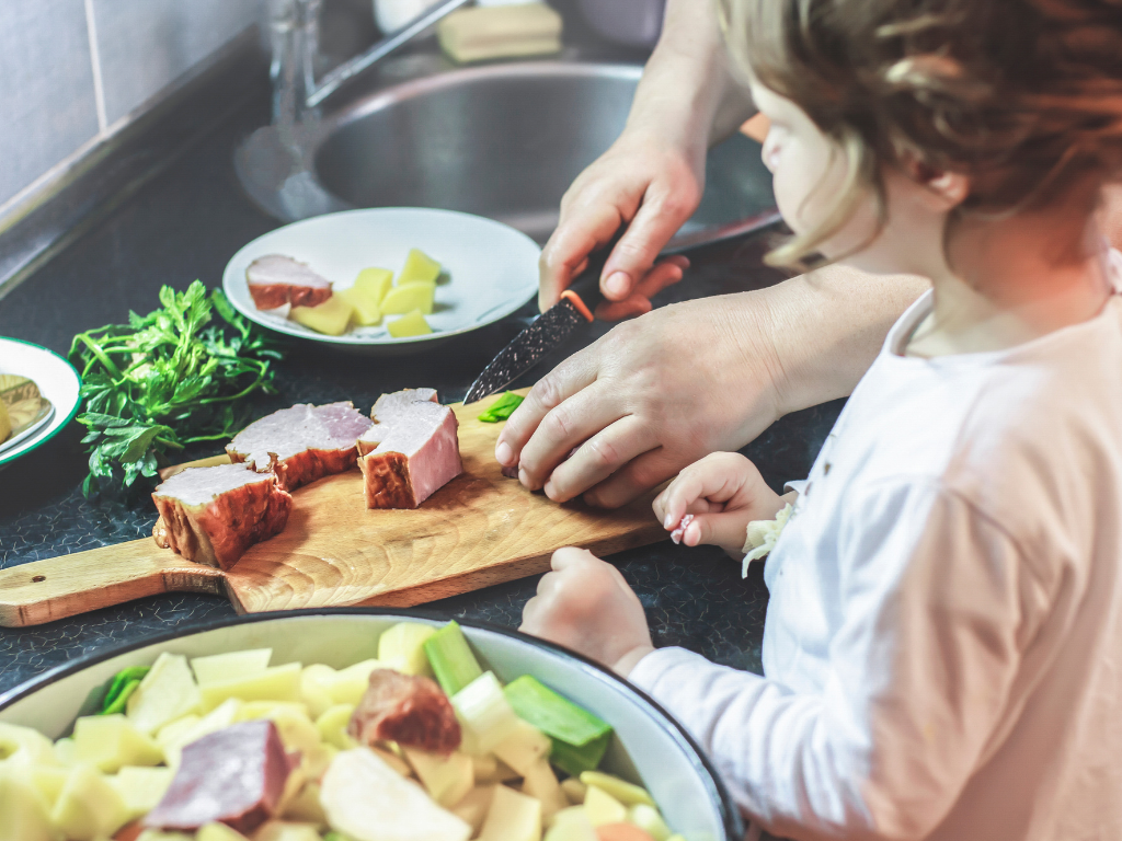 A parent and child prepare a hearty homemade meal together, highlighting family-friendly cooking classes near Mokena, Crest Hill, and Chicago. A perfect bonding and learning experience