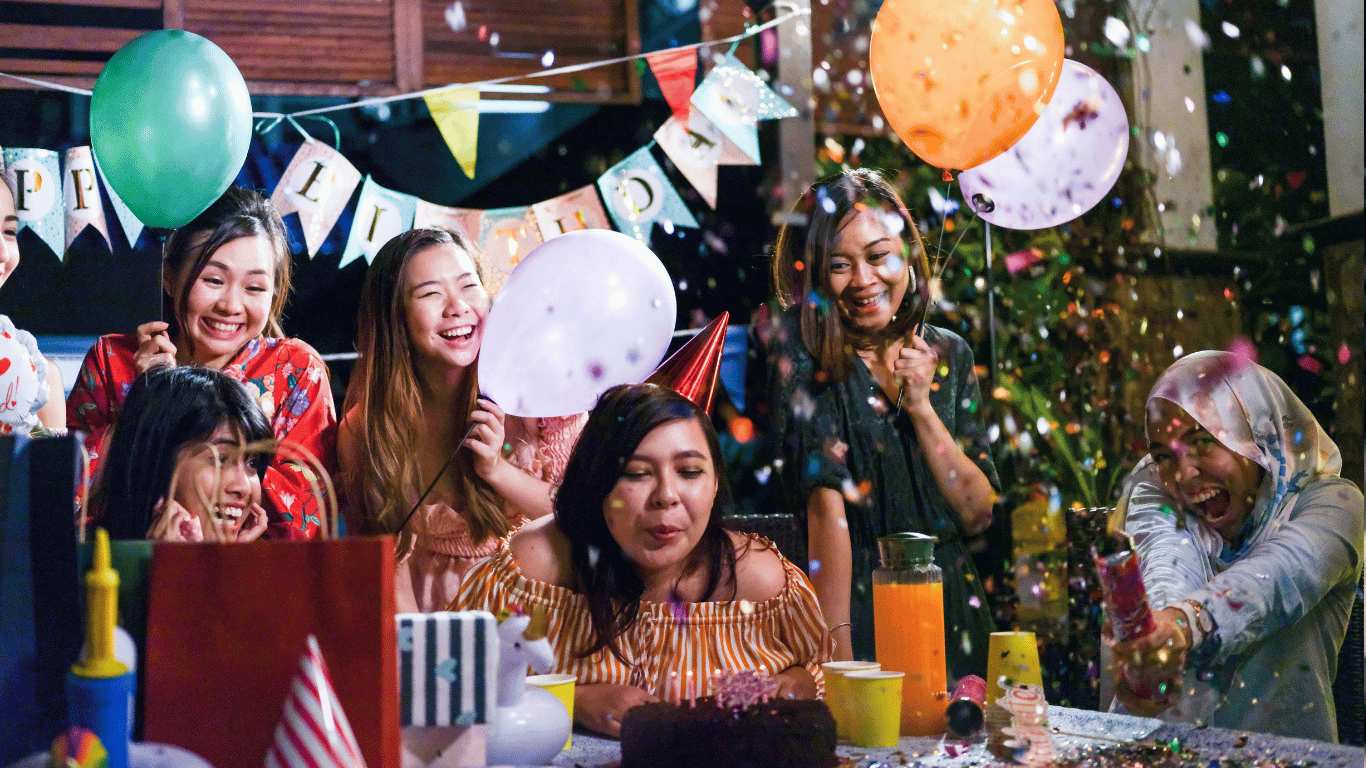 Group of friends celebrating a birthday with balloons, confetti, and cake during a private event at Farmhouse Academy near Mokena, New Lenox, and Tinley Park, Illinois