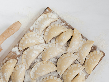 Freshly made dumplings dusted with flour, ready to cook—perfect for showcasing authentic hands-on cooking classes in Mokena, Crest Hill, and the greater Chicago area
