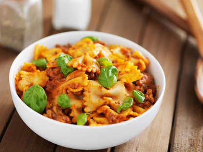 Delicious bowtie pasta in hearty Bolognese sauce garnished with fresh basil—perfect for showcasing Italian cooking class experiences in Mokena, Crest Hill, and Chicago