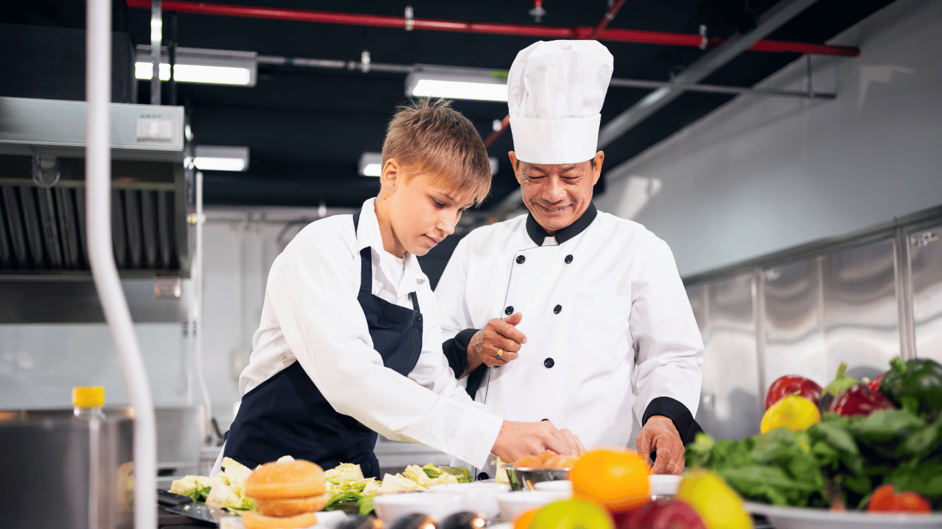 Teen learning culinary techniques from a professional chef during a mentorship-focused cooking class at Farmhouse Academy near Joliet, Shorewood, and Crest Hill, Illinois